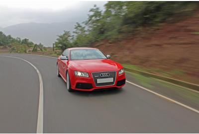 A red Audi driving along a road